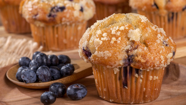 blueberry muffins on wooden background with blueberries